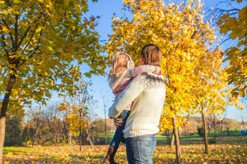 Fototapeta premium Back view of Little girl with happy father having fun in autumn