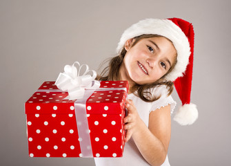 Small girl in santa hat with christmas gift