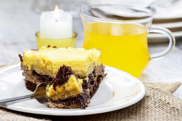 Piece of yellow and brown cake on wooden table. Selective focus