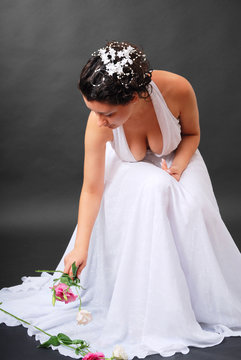 Happy bride picking up flowers.