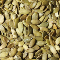 Pumpkin seeds background. Peeled and green
