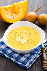 Pumpkin soup in white bowl