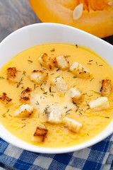 Pumpkin soup in white bowl