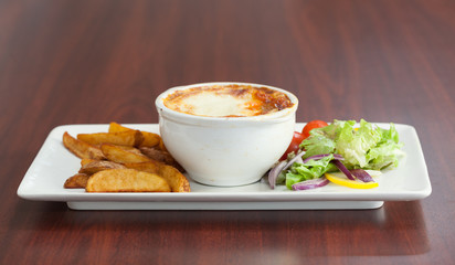 Front view of lasagna with potatoes and salad