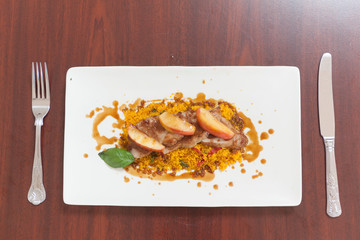 Overhead view of couscous dish with meat and apple