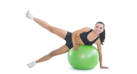 Fototapeta na wymiar Content active woman doing an exercise on a green fitness ball