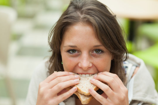Close-up portrait of a female student eating sandwich