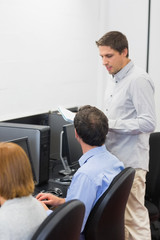 Teacher and mature students in computer room