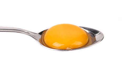 Egg yolk on a silver spoon.