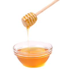 Honey dripping from a wooden dipper.