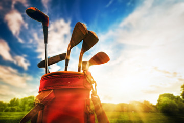 Golf equipment. Professional golf clubs at sunset