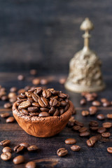 Vintage clay bowl with coffee beans on a wooden board