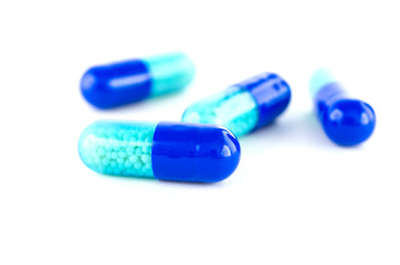 close up of blue pill on white background