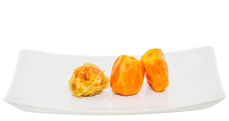 Fresh and fried chempedak arils in a white plate.