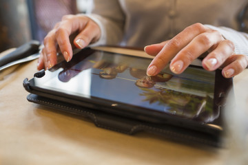 Woman using digital tablet in a cafe, vacation pictures