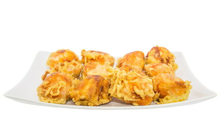 Fried chempedak arils in a white plate.