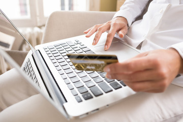 Woman's holding a credit card and using laptop, online shopping