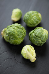 Vertical shot of brussels sprouts, dark wooden background