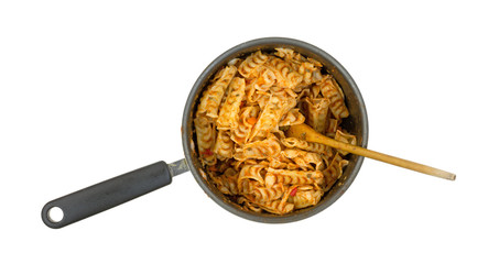 A small saucepan filled with cooked pasta and a spoon