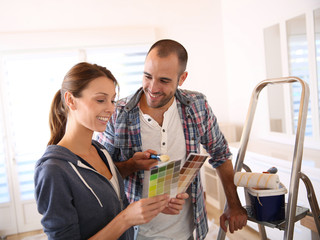 Couple in new house choosing color for walls