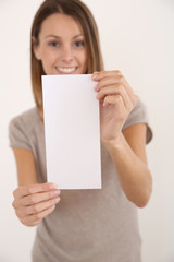 Fototapeta premium Cheerful girl on white background holding leaflet for message