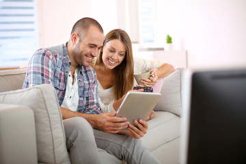 Young couple at home looking for tv progam
