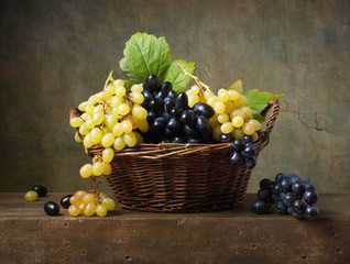 Still life with grapes in a basket on the table