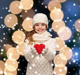 girl in winter clothes with small red heart