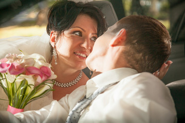 Newly married couple hugging in car