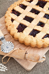 Obraz na płótnie Canvas Homemade cherry jam tart over a chopping board