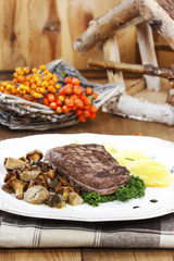 Roasted beef with mushrooms in autumn setting. Rowan berry