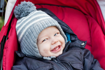 happy baby boy sitting in a stroller