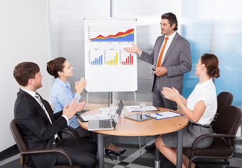 Coworkers Applauding Businessman