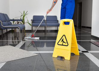Man With Mop And Wet Floor Sign - obrazy, fototapety, plakaty