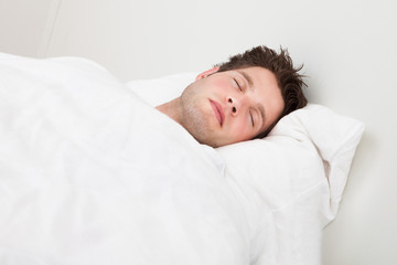 Fototapeta na wymiar Man Sleeping On Bed