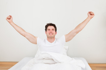 Man With Arm Raised On Bed