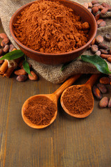 Cocoa powder and cocoa beans  on wooden background