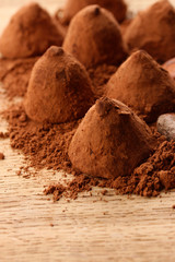 Chocolate truffles and cocoa, on wooden background