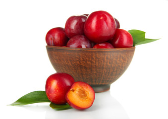Ripe plums in bowl isolated on white