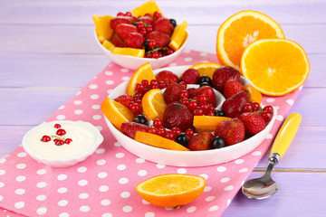 Useful fruit salad in plates on wooden table close-up