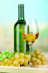Fototapeta na wymiar Wine bottle and glass of wine on tray, on bright background