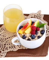 Oatmeal in cup with berries on napkins isolated on white