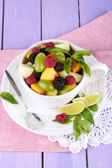 Fruit salad in cup on napkin on wooden table