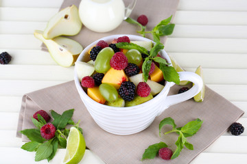 Fruit salad in cup on wooden table