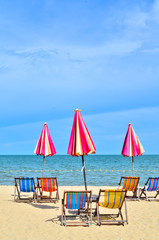 Chairs and umbellar on white sand beach.