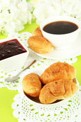 Tasty croissants and cup of coffee on table close-up