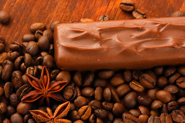 Delicious chocolate bar with coffee beans close up