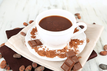 Cocoa powder in cup on napkin on wooden table