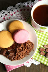 Cocoa in cup with sweets and cocoa powder