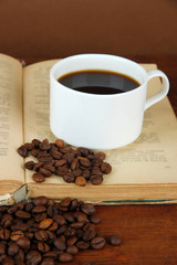 Cup of coffee with coffee beans and book